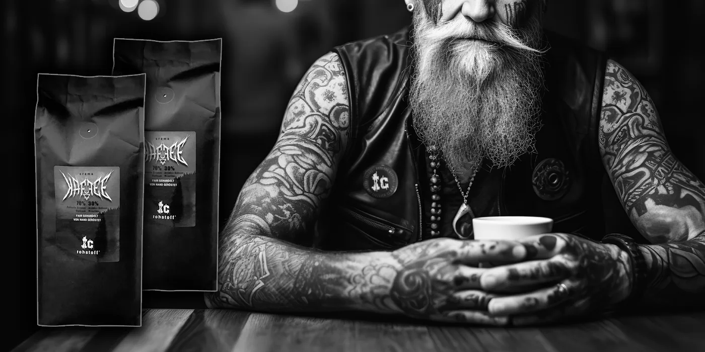 tätowierter Rocker mit Bart genießt seinen schwarzen Kaffee.